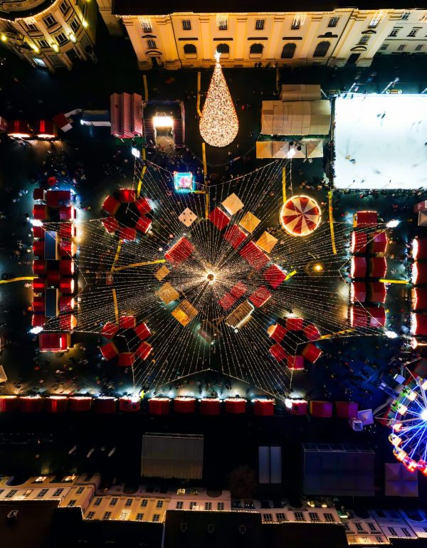 Aerial drone view of The Big Square decorated for Christmas in Sibiu, Romania Aerial drone view of The Big Square in Sibiu at night, Romania. Old city centre decorated for Christmas. Ferris wheel, skating rink, old traditional buildings, people